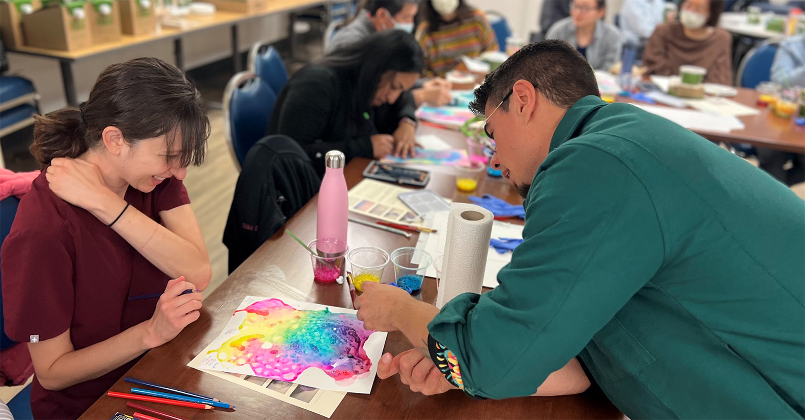 Two Individuals pour over a piece of visual artwork