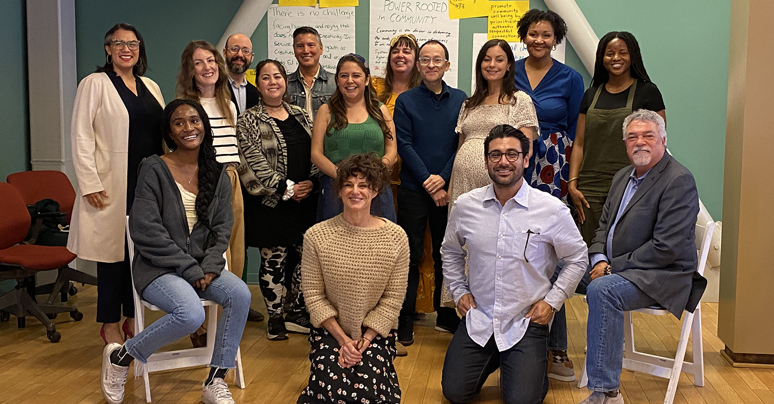 fourteen indivudals of differet ages and races pose for the camera